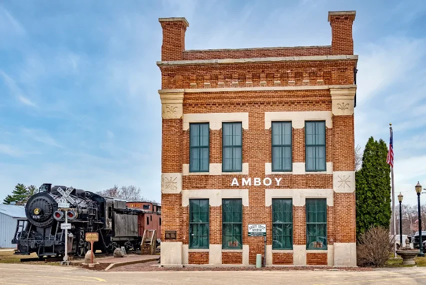The depot's front elevation with its carved limestone trim and the steam locomotive nearby